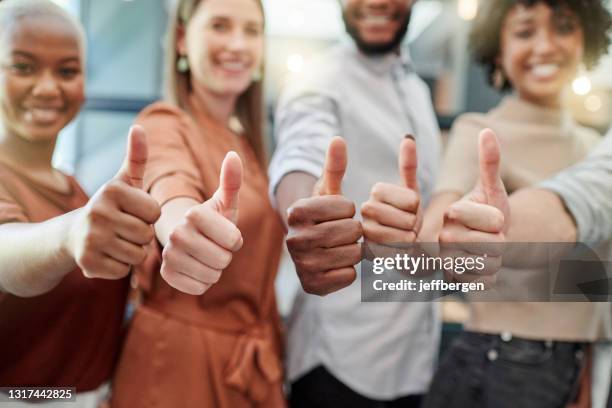 closeup shot of a group of businesspeople showing thumbs up - thumbs up stock pictures, royalty-free photos & images