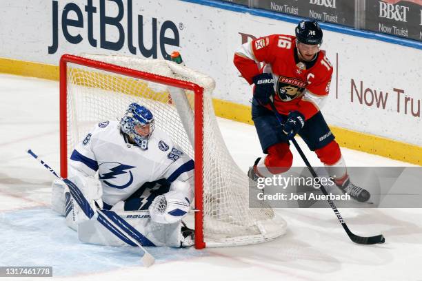 Goaltender Andrei Vasilevskiy of the Tampa Bay Lightning guards the post as Aleksander Barkov skates with the puck of the Florida Panthers at the...