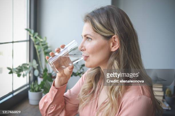attractive middle aged woman in the office ( drinking water) - drink stock pictures, royalty-free photos & images