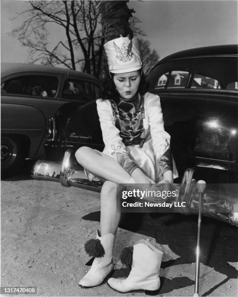 Majorette Kathleen Henry of West Hempstead, New York rubs her feet after a long walk in the St. Patrick's Day parade in Hempstead, New York on March...