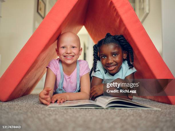 little girl with alopecia playing with a friend - bald girl stock pictures, royalty-free photos & images