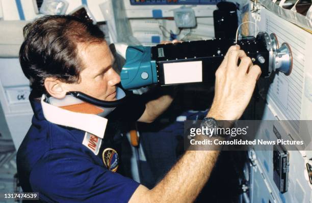 American astronaut and payload specialist Bill Nelson operates a pair of ocular counter-rolling goggles during NASA's STS 61-C mission, between...