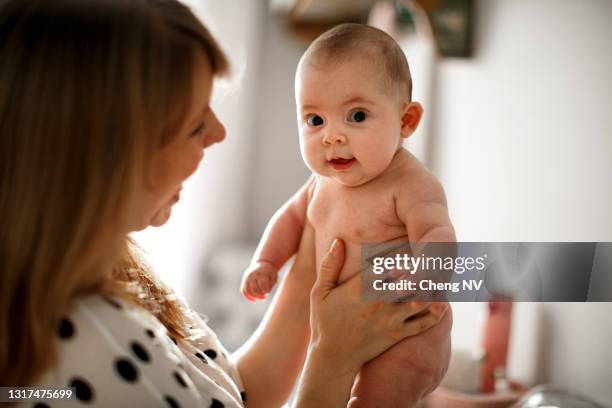 young mother changing baby clothes - changing nappy stock pictures, royalty-free photos & images