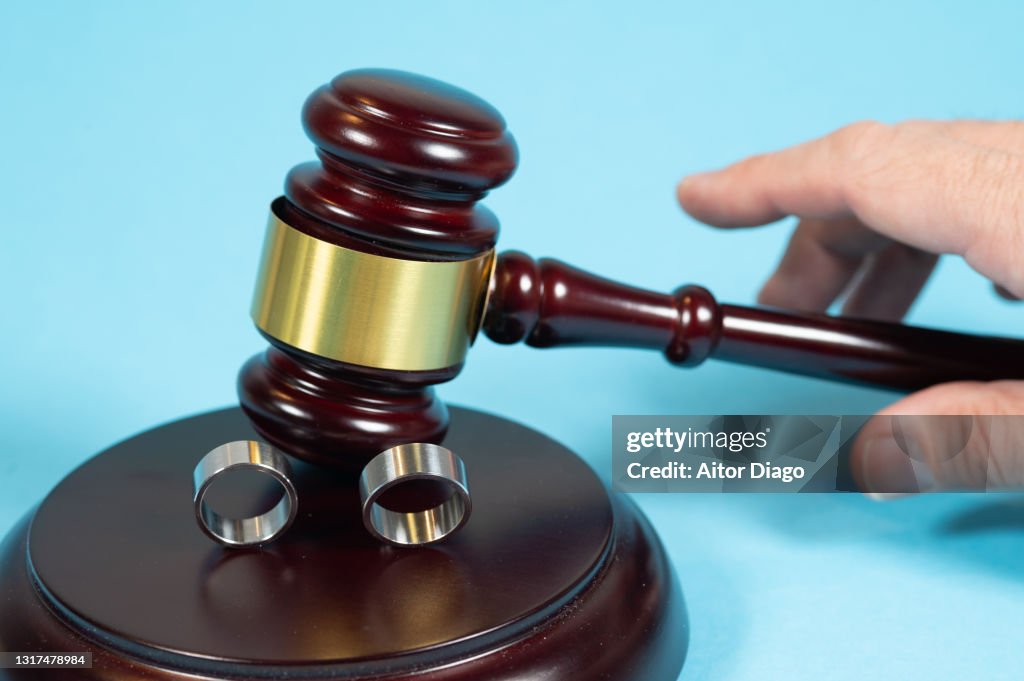 Divorce sentence or wedding. Two wedding rings and a judge passing sentence with his judge's gavel.