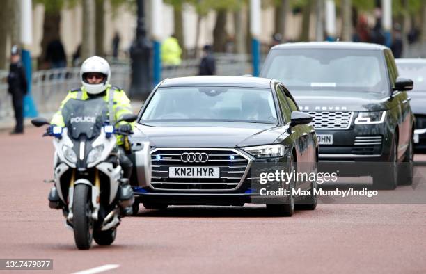 Prince Charles, Prince of Wales and Camilla, Duchess of Cornwall travel down The Mall, in their chauffeur driven Audi A8 car led by a motorcycle...