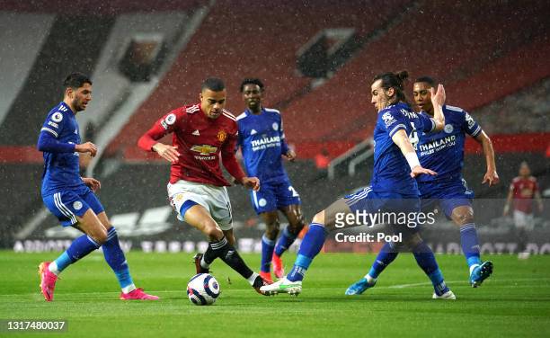 Mason Greenwood of Manchester United gets away from Ayoze Perez and Caglar Soyuncu of Leicester City before scoring their side's first goal during...