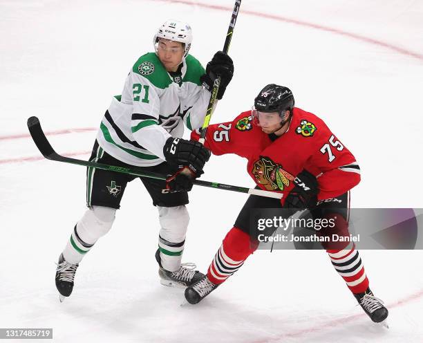 Alec Regula of the Chicago Blackhawks battles for position with Jason Robertson of the Dallas Stars at the United Center on May 10, 2021 in Chicago,...