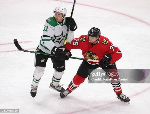 Alec Regula of the Chicago Blackhawks battles for position with Jason Robertson of the Dallas Stars at the United Center on May 10, 2021 in Chicago,...