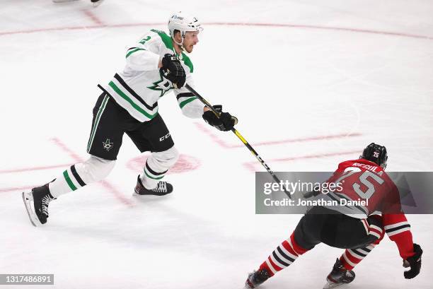 Jamie Oleksiak of the Dallas Stars shoots against Alec Regula of the Chicago Blackhawks at the United Center on May 10, 2021 in Chicago, Illinois....