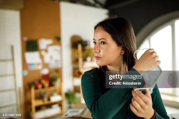 young woman taking off the protective face mask she was wearing - removing surgical mask stock pictures, royalty-free photos & images