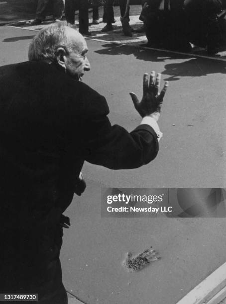 Planner Robert Moses impresses his hand in cement at the Hollywood Pavilion at the World's Fair in Flushing Meadow, New York on March 31, 1964.