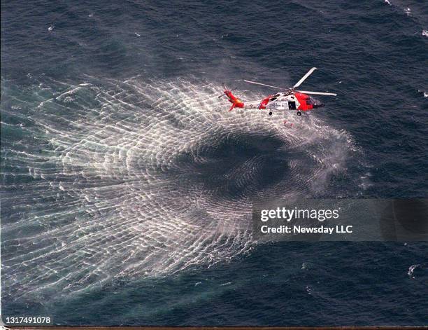 Martha's Vineyard, MA: A Coast Guard helicopter lifts a rescue swimmer after the swimmer jumped into the water on July 17, 1999 to look for debris...