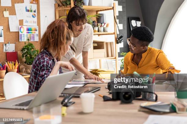 three female colleagues having a business meeting at the graphic design studio - 設計室 個照片及圖片檔