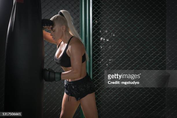 weibliche boxer boxsack sitzung. eine pause einlegen - boxing womens stock-fotos und bilder