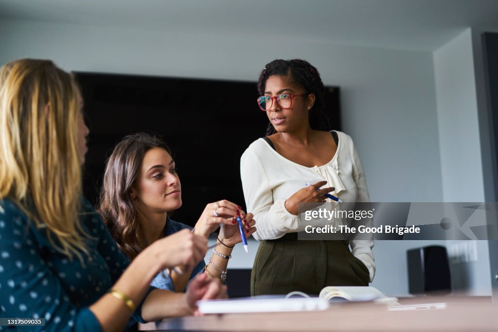 Businesswoman leading discussion during project meeting in office conference room