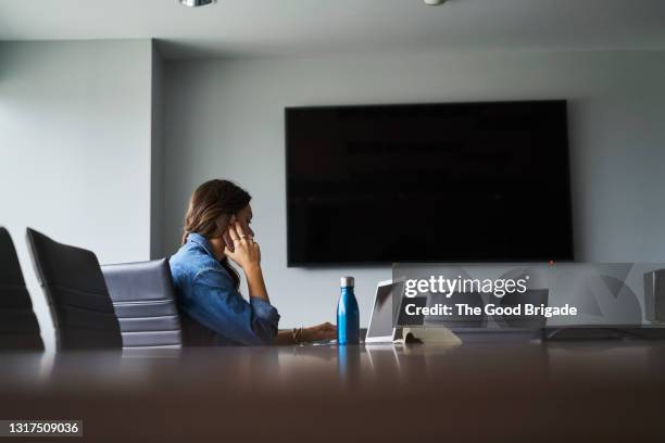 businesswoman talking on smart phone in conference room - reusable water bottle office stock pictures, royalty-free photos & images