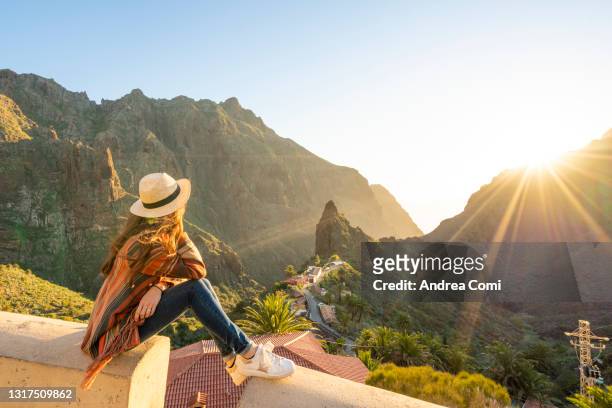 tourist admiring masca village at sunset. masca, tenerife, canary islands - journey fotografías e imágenes de stock