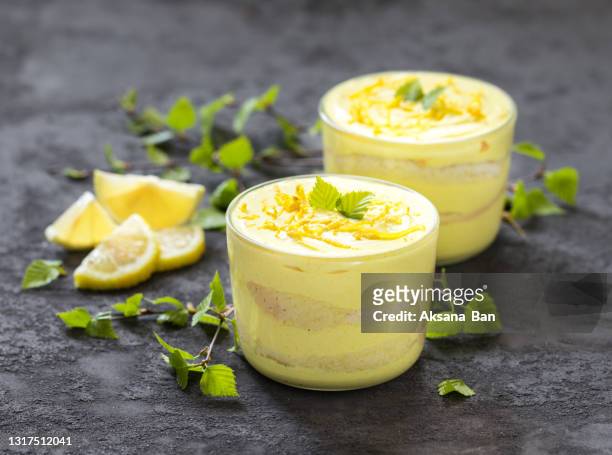 italian mascarpone cheese biscuit lemon dessert, tiramisu in a glass cup on a dark gray background - tiramisu stock pictures, royalty-free photos & images