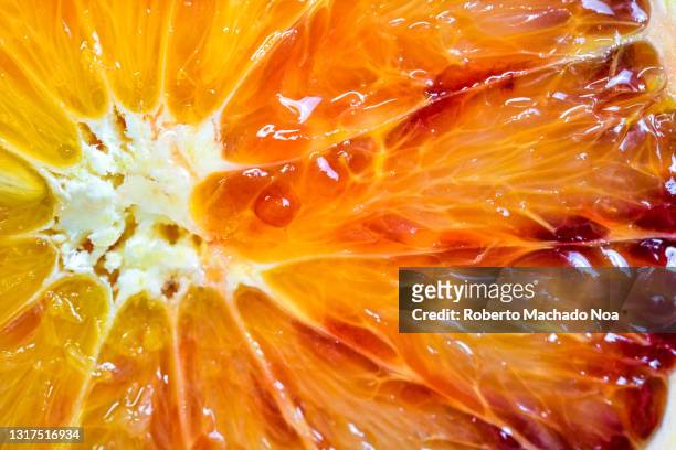 close up of blood orange fruit - bloedsinaasappel stockfoto's en -beelden