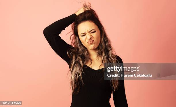 la joven que se rindió, lamentando lo sucedido, sosteniendo su cabello con la mano. - in case of discomfort fotografías e imágenes de stock