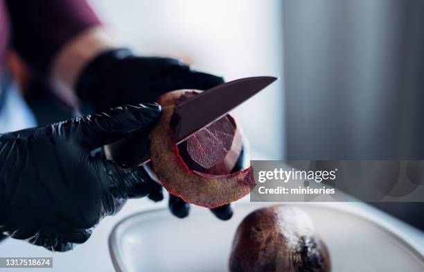 female hands peel the beetroot with a knife - black glove stock pictures, royalty-free photos & images