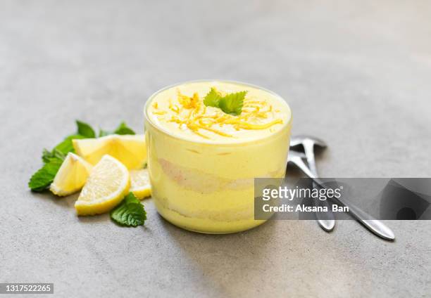 tiramisu, lemon mascarpone cheese biscuit dessert in a glass cup on a light gray background - tiramisu stockfoto's en -beelden