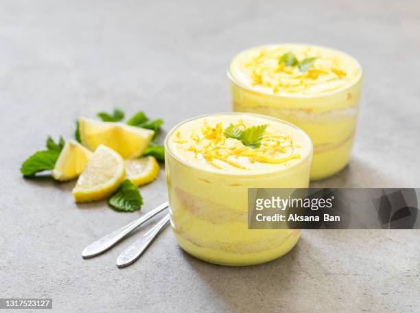 italian mascarpone cheese biscuit lemon dessert, tiramisu in a glass cup on a light gray background - ティラミス　ガラス ストックフォトと画像