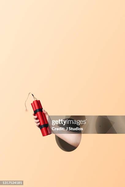 hand holding a bundle of dynamite - dynamite stock pictures, royalty-free photos & images