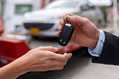 Close-up on a salesman delivering a car while handling the keys