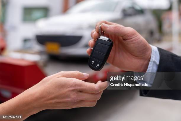 close-up on a salesman delivering a car while handling the keys - car towing stock pictures, royalty-free photos & images