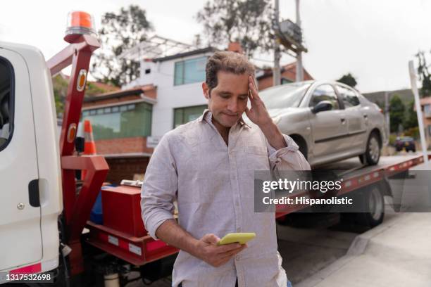 hombre que tiene problemas con su coche y llama a asistencia en carretera - remolcar fotografías e imágenes de stock