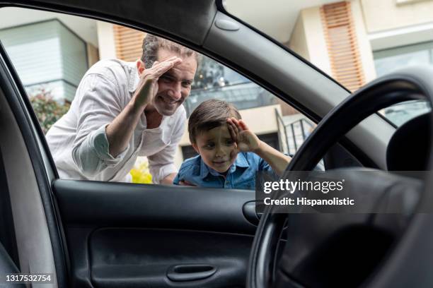 father and son looking into a car through the window - peeking stock pictures, royalty-free photos & images