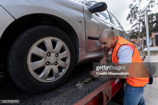 latin american tow truck operator towing a car - tow truck stock pictures, royalty-free photos & images