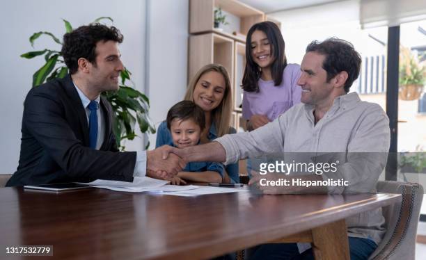 real estate agent closing a deal with a family buying a house - door to door salesperson stock pictures, royalty-free photos & images