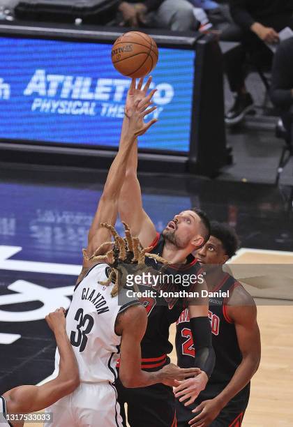 Nikola Vucevic of the Chicago Bulls rebounds over Nicolas Claxton of the Brooklyn Nets at the United Center on May 11, 2021 in Chicago, Illinois....
