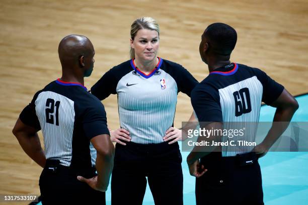 Referee Dedric Taylor, referee Jenna Schroeder, and referee James Williams look on under a timeout during the fourth quarter of the game between the...