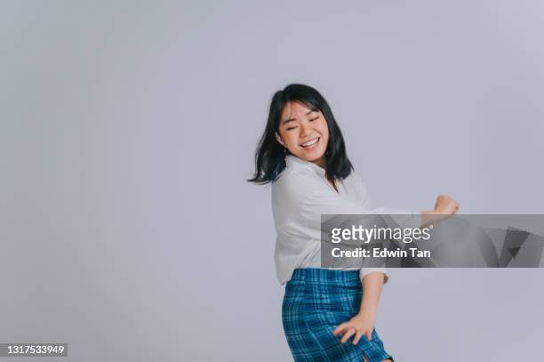asian chinese teenage girl dancing having fun in studio shoot with gray background - skirt isolated stock pictures, royalty-free photos & images