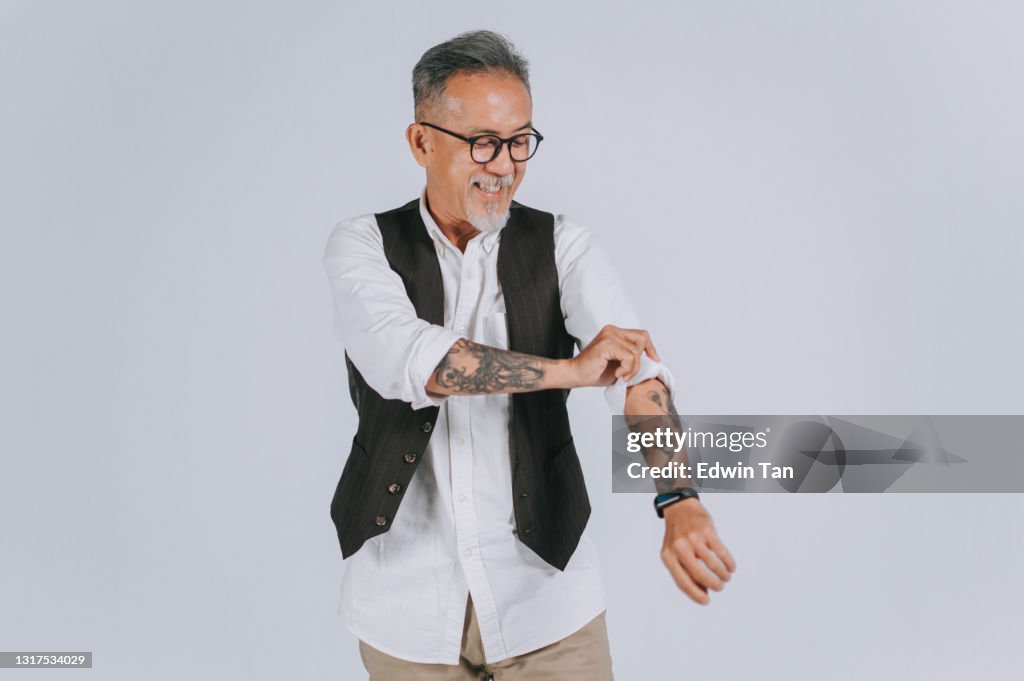 Asiatische chinesische Senior Mann graue Haare mit Haar Stoppeln rollen Ärmel lächelnd glücklich grau Hintergrund