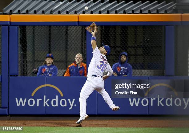 Michael Conforto of the New York Mets catches a sacrifice fly hit by Pat Valaika of the Baltimore Orioles as a run is scored in the seventh inning at...