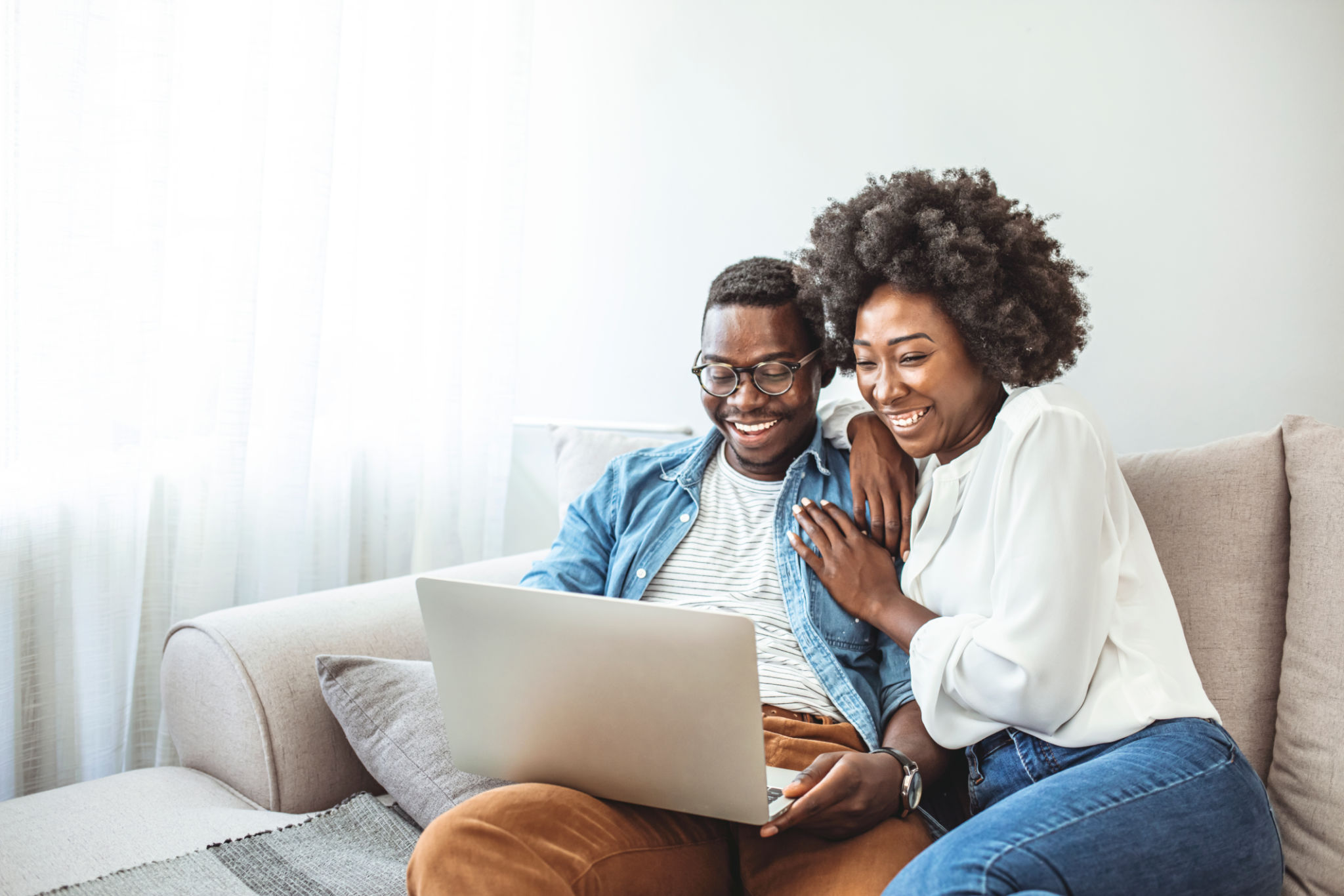 Black couple using laptop at home look at each other. Black couple using laptop at home look at each other.