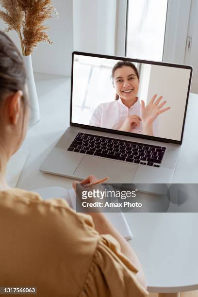 back view and close up of with non-caucasian woman making video call in modern home interior. diverse workers or friends chatting online, web conference, consulting client. - teacher taking attendance stock pictures, royalty-free photos & images