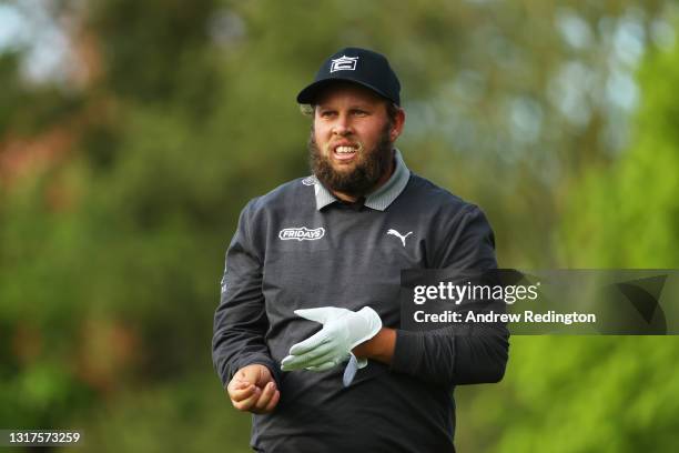 Andrew Johnston of England takes his glove off as he walks down the twelfth during the First Round of The Betfred British Masters hosted by Danny...