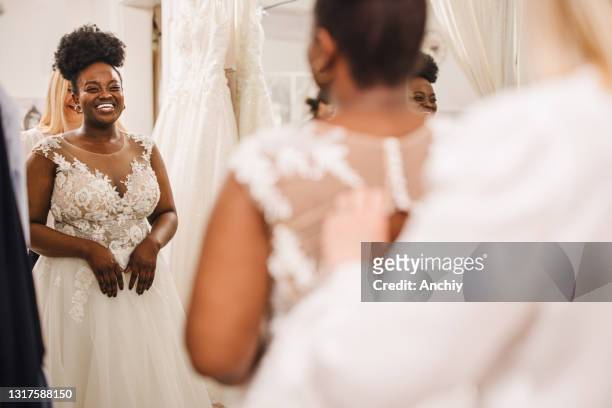 winkel assistent helpen bruid krijgen in trouwjurk - wedding dress stockfoto's en -beelden