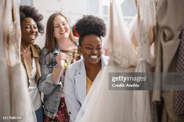amiche che guardano abiti da sposa su rack - african american wedding foto e immagini stock