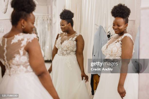 mariée à être se regarde dans le miroir plein d’admiration - robe de mariée photos et images de collection