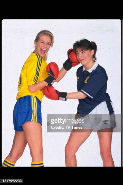 Television presenters Lorraine Kelly and Ulrika Jonsson posed with boxing gloves and football jerseys , circa June, 1990.