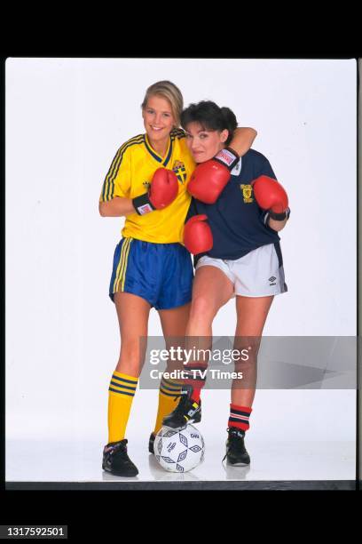 Television presenters Lorraine Kelly and Ulrika Jonsson posed with boxing gloves and football jerseys , circa June, 1990.