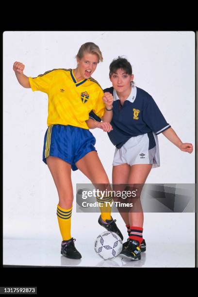 Television presenters Lorraine Kelly and Ulrika Jonsson posed with a football and sports jerseys , circa June, 1990.
