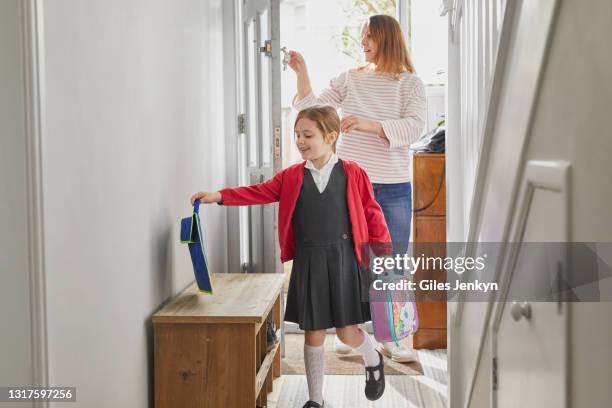 mother and young daughter entering house - woman entering home stock pictures, royalty-free photos & images