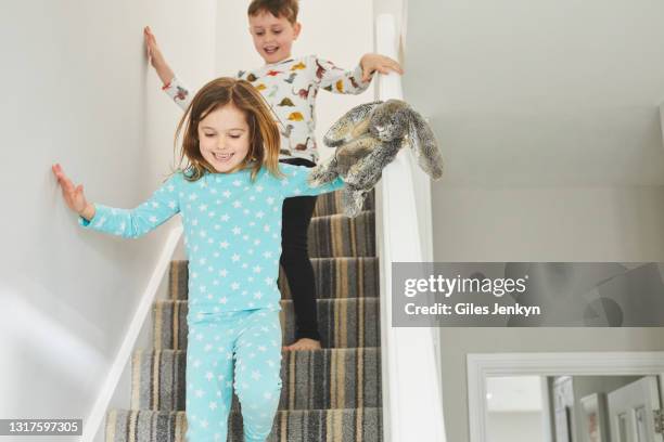 young children running downstairs - kids pajamas stock pictures, royalty-free photos & images